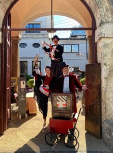 Elegante Begruesser mit Drehorgel, Stelzengeher und Marionette Trio in historischem Ambiente
