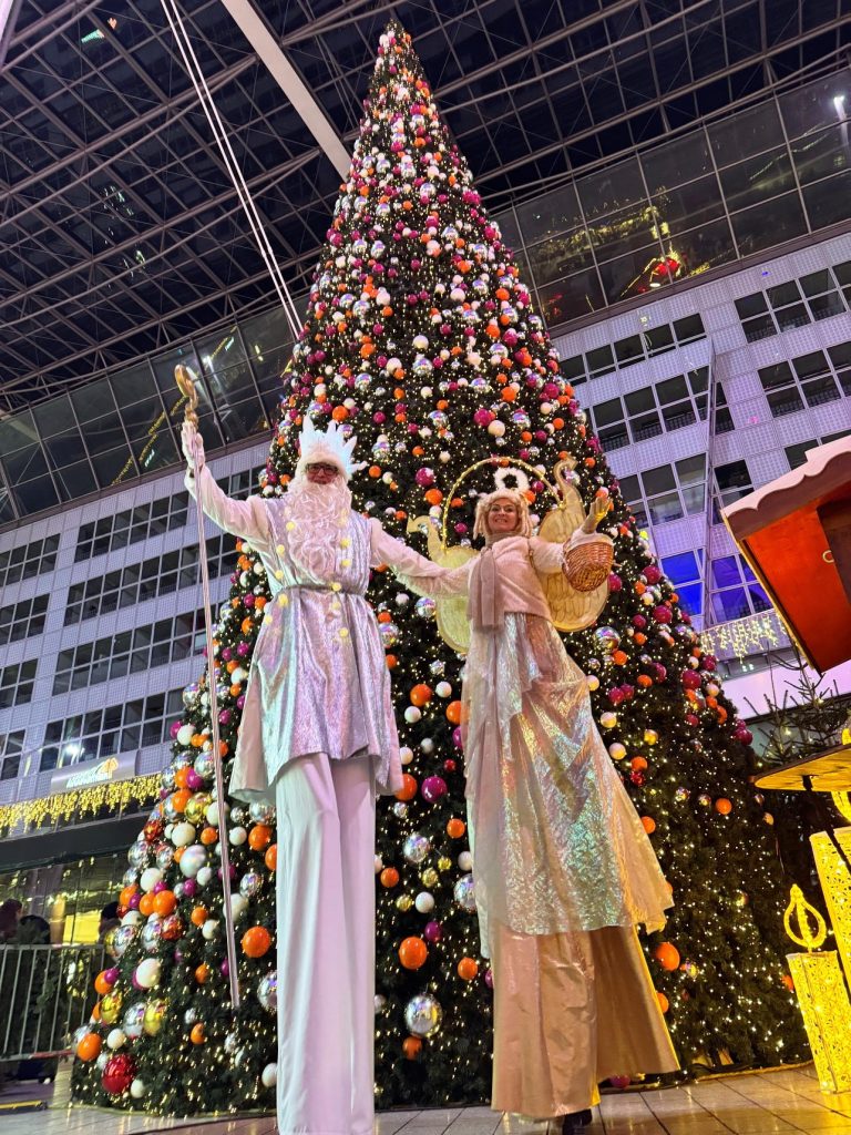 Stelzengeher Duo in Silber und Gold vor Megaweihnachtsbaum
