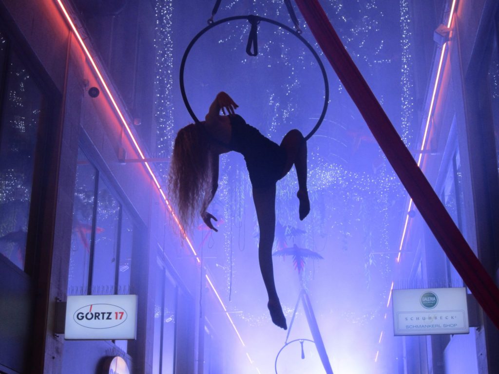 Luftring Artistin in eleganter Shopping Mall in violettem Effektlicht